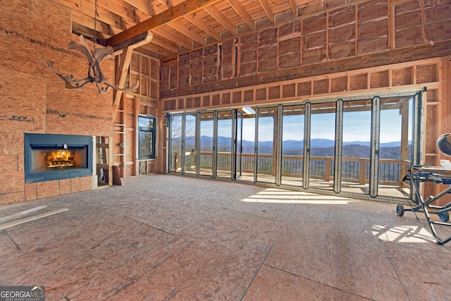 unfurnished living room with a mountain view, a towering ceiling, and a fireplace