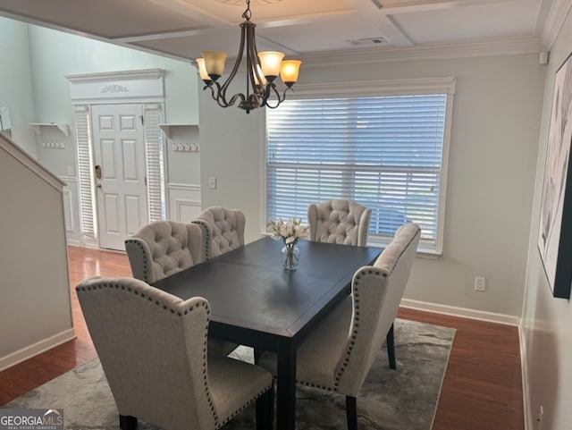 dining area featuring dark hardwood / wood-style flooring, ornamental molding, coffered ceiling, and an inviting chandelier