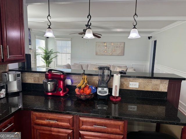 kitchen featuring dark stone counters, decorative backsplash, crown molding, and pendant lighting