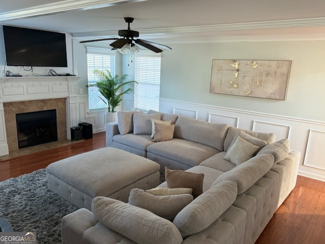 living room featuring hardwood / wood-style floors, ceiling fan, and crown molding