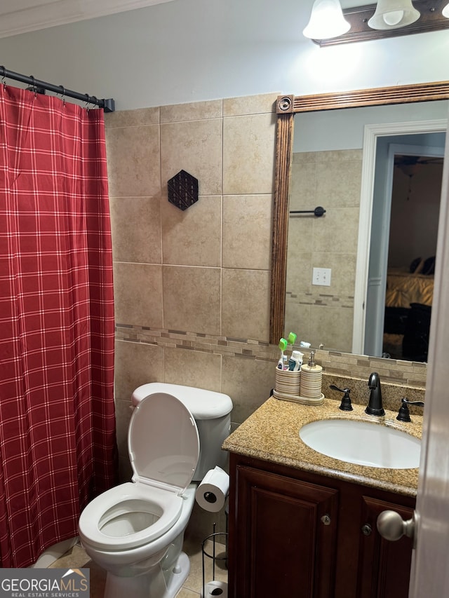 bathroom featuring tile patterned flooring, toilet, vanity, tile walls, and ornamental molding