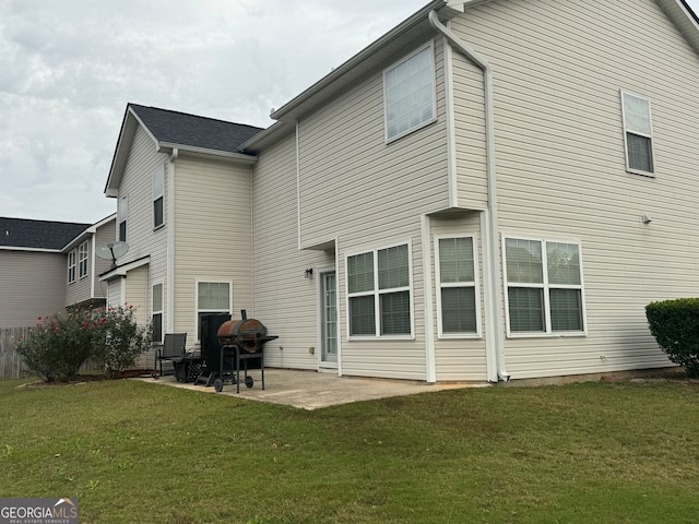 rear view of house featuring a patio and a lawn