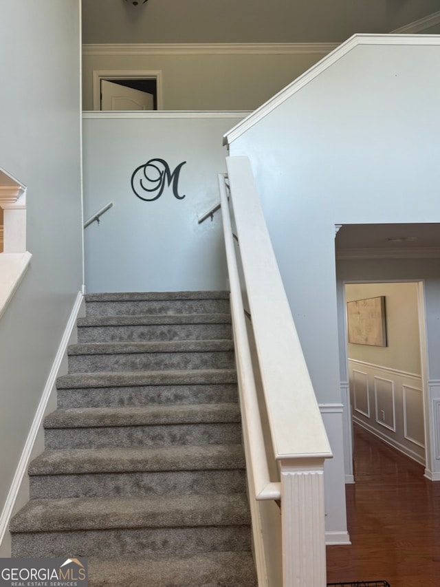 stairway featuring hardwood / wood-style flooring and crown molding