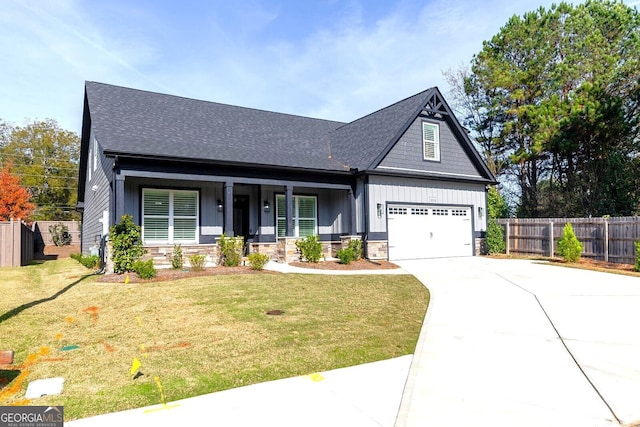 craftsman-style house with covered porch, a front yard, and a garage