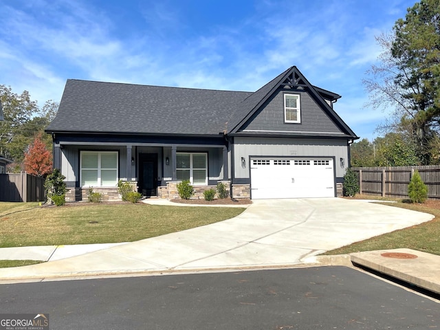 craftsman house featuring covered porch, a garage, and a front yard