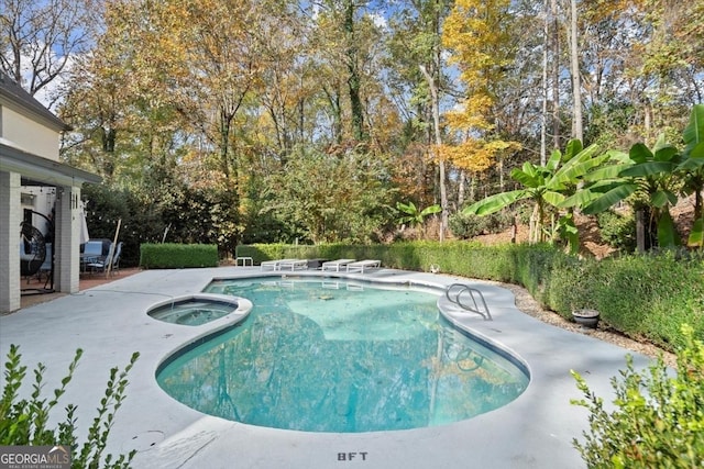 view of swimming pool featuring an in ground hot tub and a patio