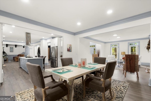 dining room with crown molding and light hardwood / wood-style flooring