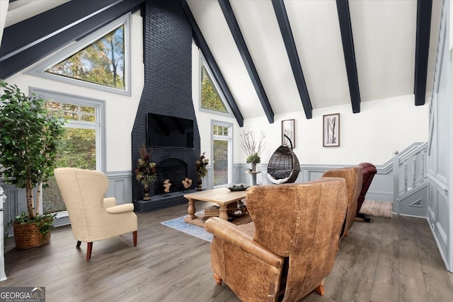 living room featuring hardwood / wood-style flooring, a large fireplace, and high vaulted ceiling