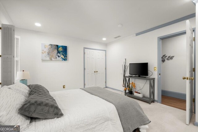 carpeted bedroom featuring ornamental molding and a closet