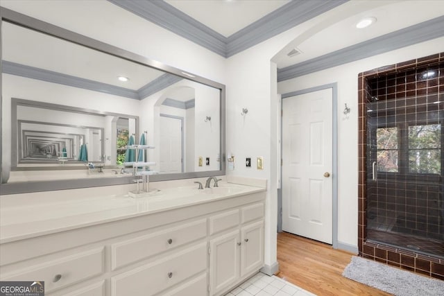 bathroom with vanity, hardwood / wood-style floors, crown molding, and tiled shower