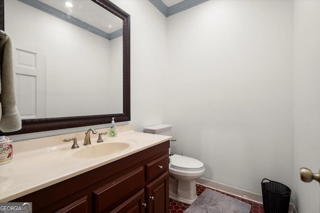 bathroom with tile patterned flooring, vanity, ornamental molding, and toilet