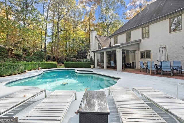 view of swimming pool featuring an in ground hot tub and a patio area