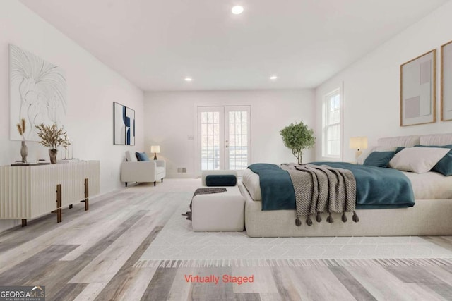 bedroom with multiple windows, french doors, and light hardwood / wood-style flooring