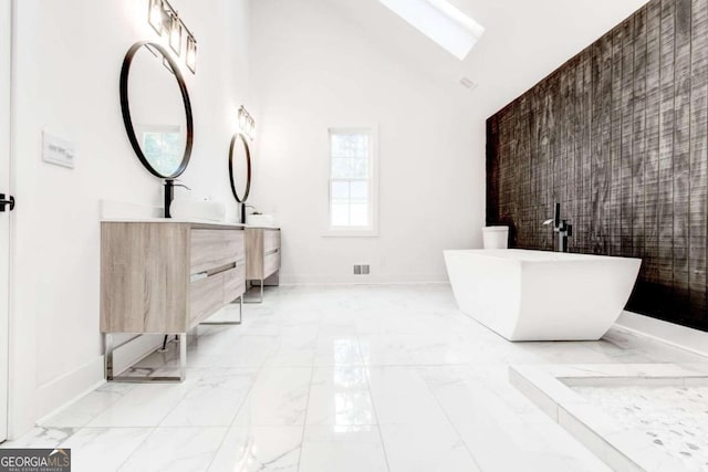 bathroom with high vaulted ceiling, vanity, and a bathing tub