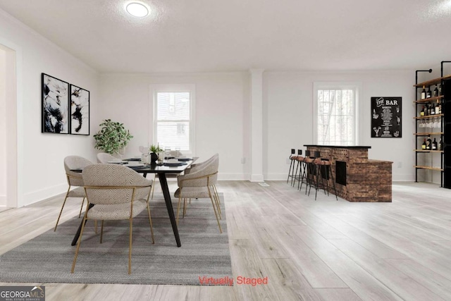 dining space featuring plenty of natural light, a textured ceiling, and light hardwood / wood-style flooring