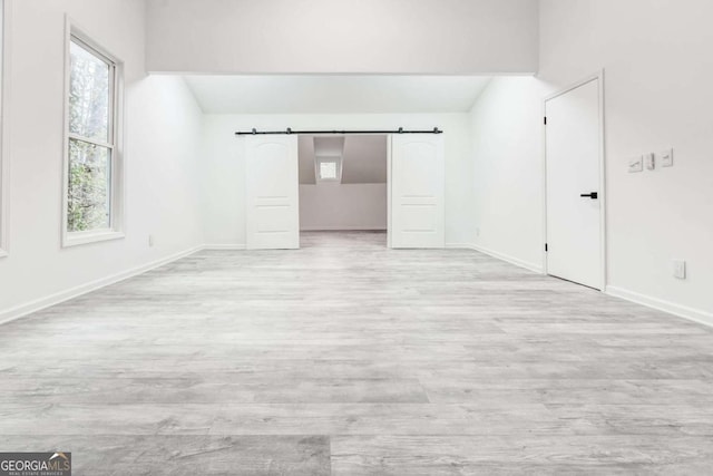 spare room featuring light hardwood / wood-style floors and a barn door