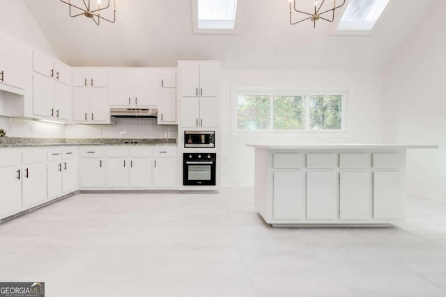 kitchen with hanging light fixtures, white cabinets, lofted ceiling, stainless steel microwave, and black oven