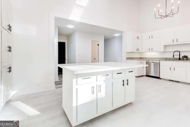 kitchen with white cabinetry, stainless steel dishwasher, sink, and pendant lighting