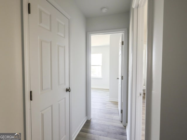 hall with light wood finished floors and baseboards