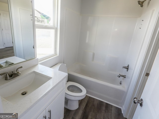 full bathroom featuring toilet, tub / shower combination, wood finished floors, and vanity