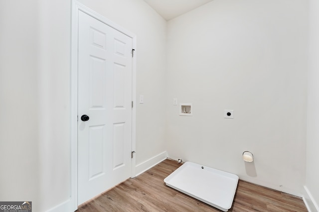 clothes washing area featuring hookup for an electric dryer, light hardwood / wood-style floors, hookup for a gas dryer, and washer hookup