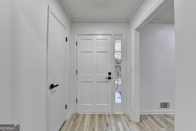 foyer entrance with light wood-type flooring and ornamental molding