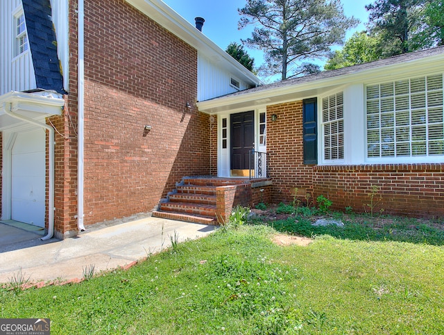 entrance to property featuring a lawn