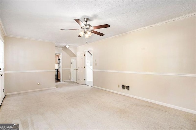 unfurnished room featuring ceiling fan, light colored carpet, ornamental molding, and a textured ceiling