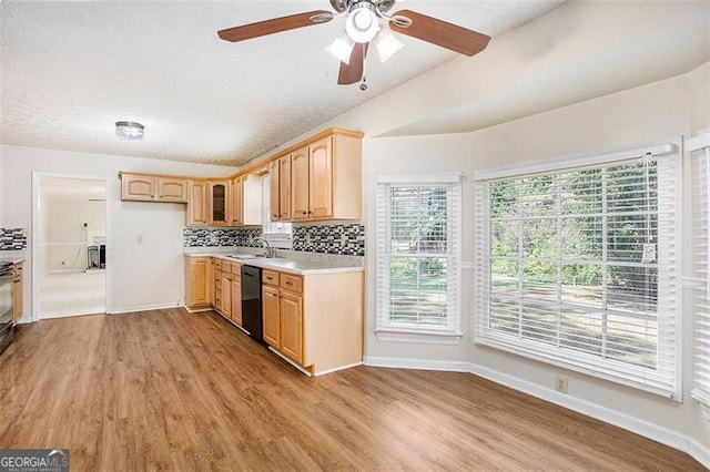 kitchen featuring sink, black dishwasher, light brown cabinetry, tasteful backsplash, and light hardwood / wood-style floors