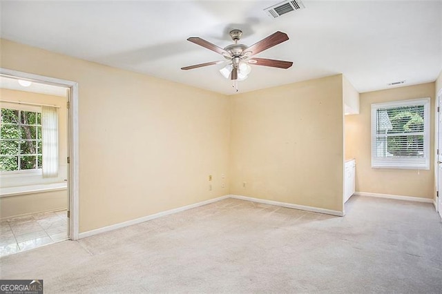 unfurnished room featuring light carpet, ceiling fan, and a healthy amount of sunlight