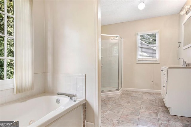 bathroom featuring a textured ceiling, vanity, and shower with separate bathtub