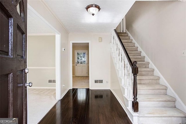 entryway featuring wood-type flooring and ornamental molding