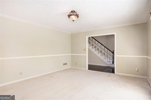 unfurnished room featuring carpet floors, a textured ceiling, and ornamental molding