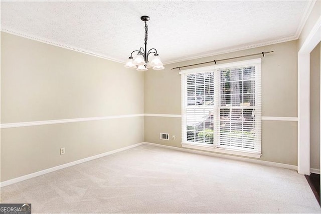 spare room featuring carpet flooring, a textured ceiling, a chandelier, and crown molding