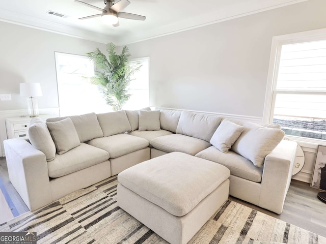 living room with light hardwood / wood-style flooring, ceiling fan, and ornamental molding