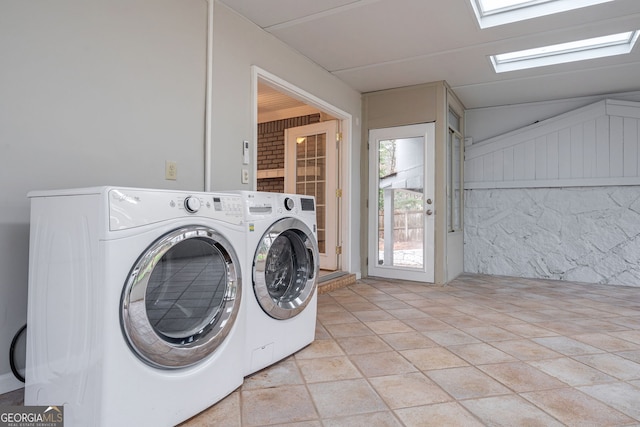 laundry room with laundry area, a skylight, and washer and clothes dryer