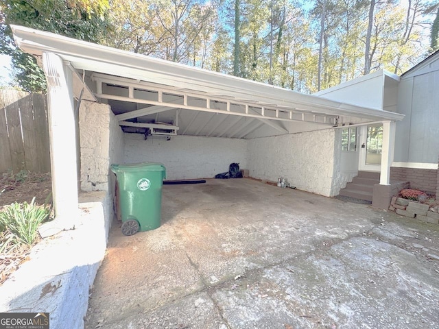 view of vehicle parking featuring an attached carport, entry steps, driveway, and fence