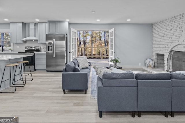 living room with a fireplace and light wood-type flooring