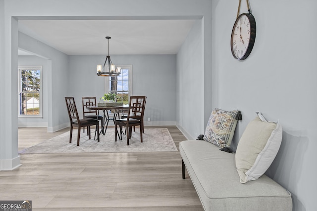 dining room with light hardwood / wood-style floors and a chandelier