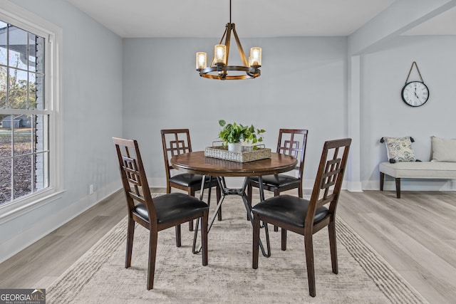 dining room with light hardwood / wood-style floors and an inviting chandelier