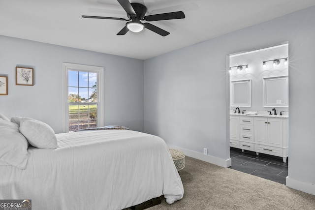 bedroom with dark colored carpet, ensuite bathroom, ceiling fan, and sink