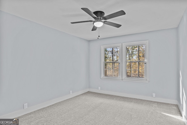 carpeted spare room featuring ceiling fan