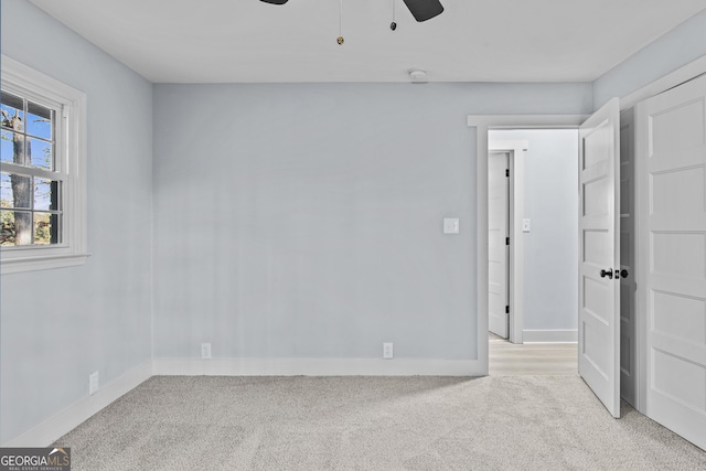 carpeted spare room with ceiling fan