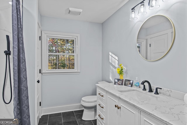 bathroom featuring tile patterned flooring, vanity, and toilet