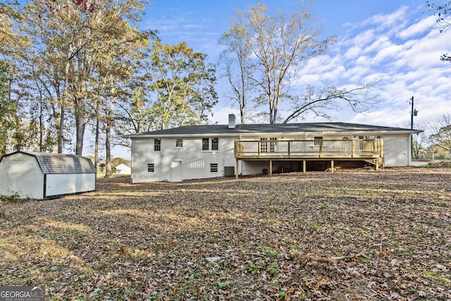 rear view of house featuring a storage unit and a wooden deck