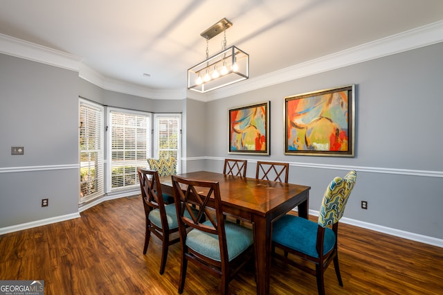 dining room with dark hardwood / wood-style flooring, ornamental molding, and a notable chandelier