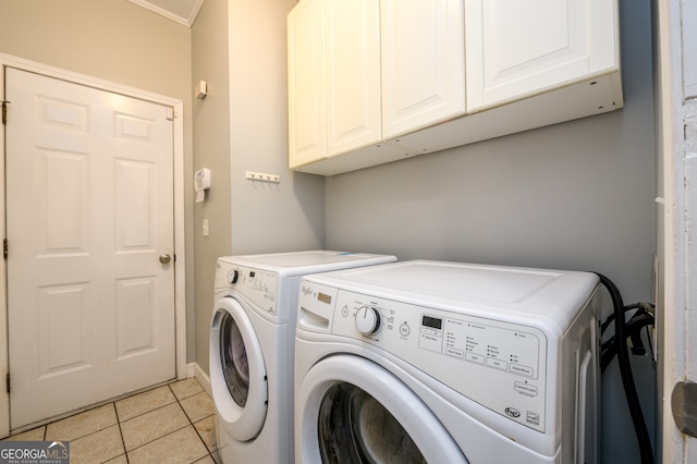 laundry room with cabinets, light tile patterned floors, washing machine and dryer, and ornamental molding