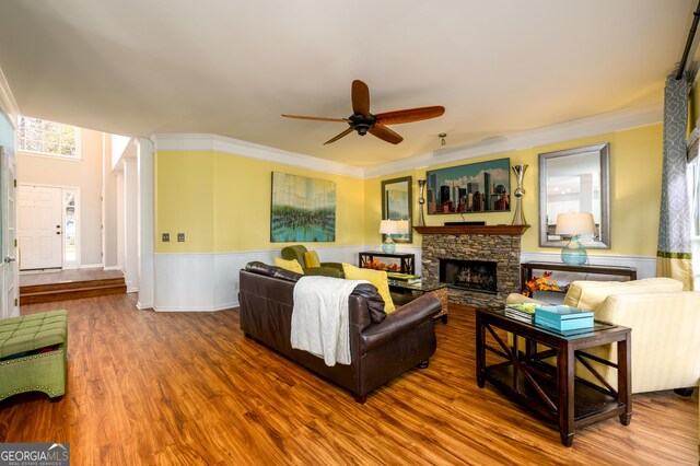 living room featuring a fireplace, ceiling fan, hardwood / wood-style floors, and ornamental molding