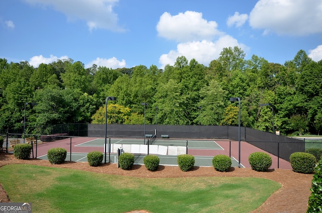 view of tennis court featuring a lawn