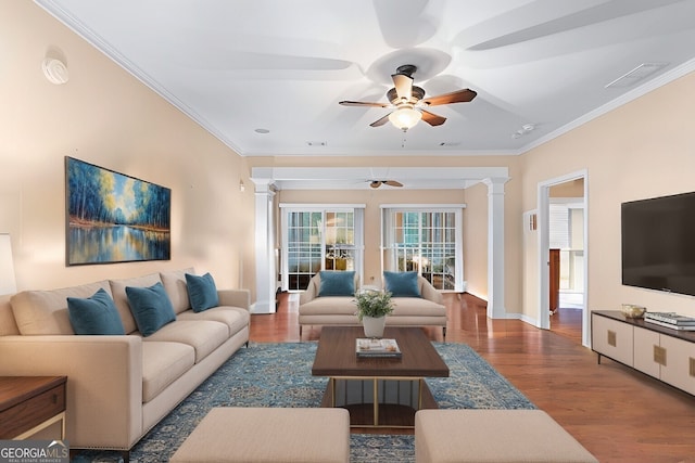 living area with crown molding, decorative columns, and wood finished floors